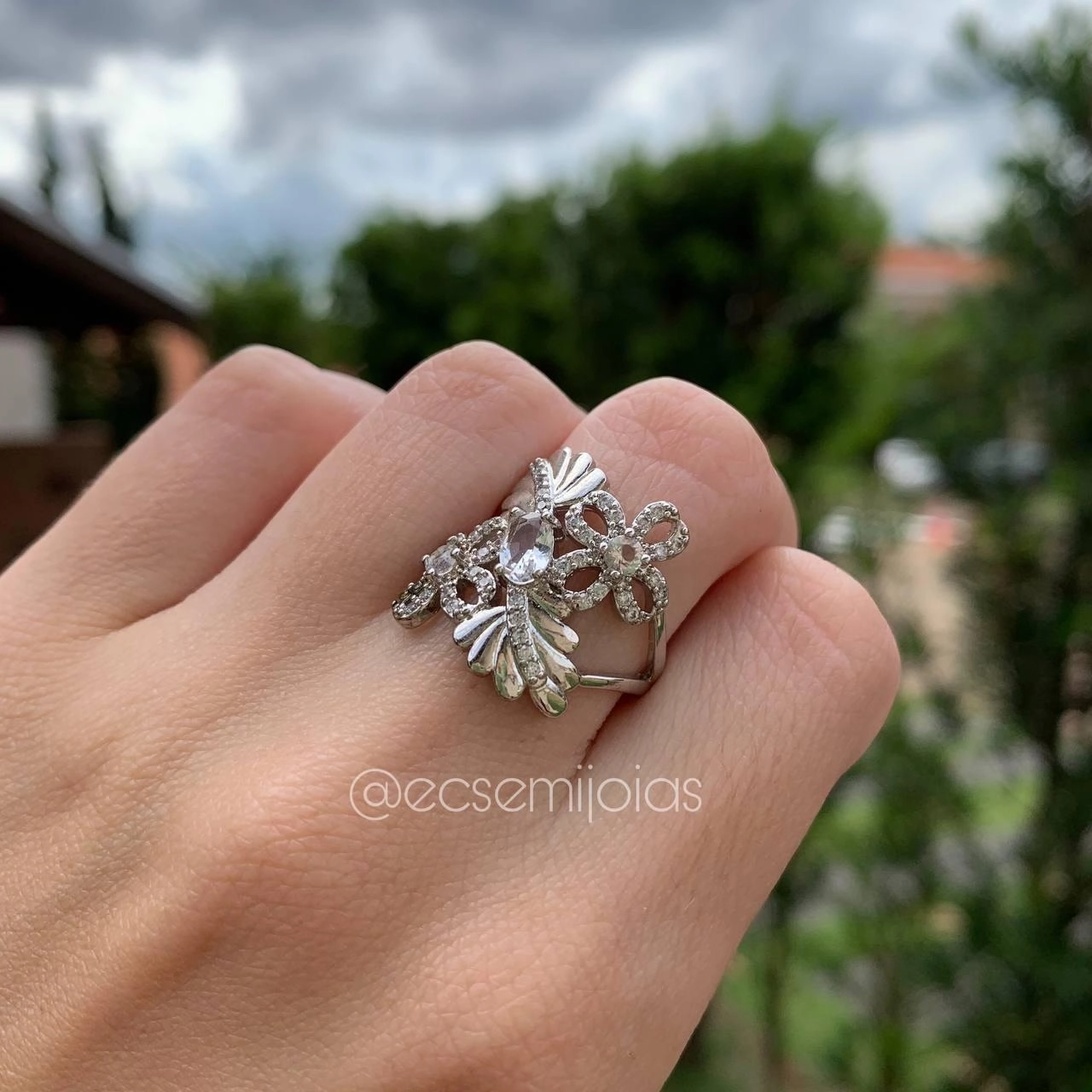 Anel vazado com flor, cravejada, folha com fileira de zircônia e pedra oval no centro  banhado ródio branco