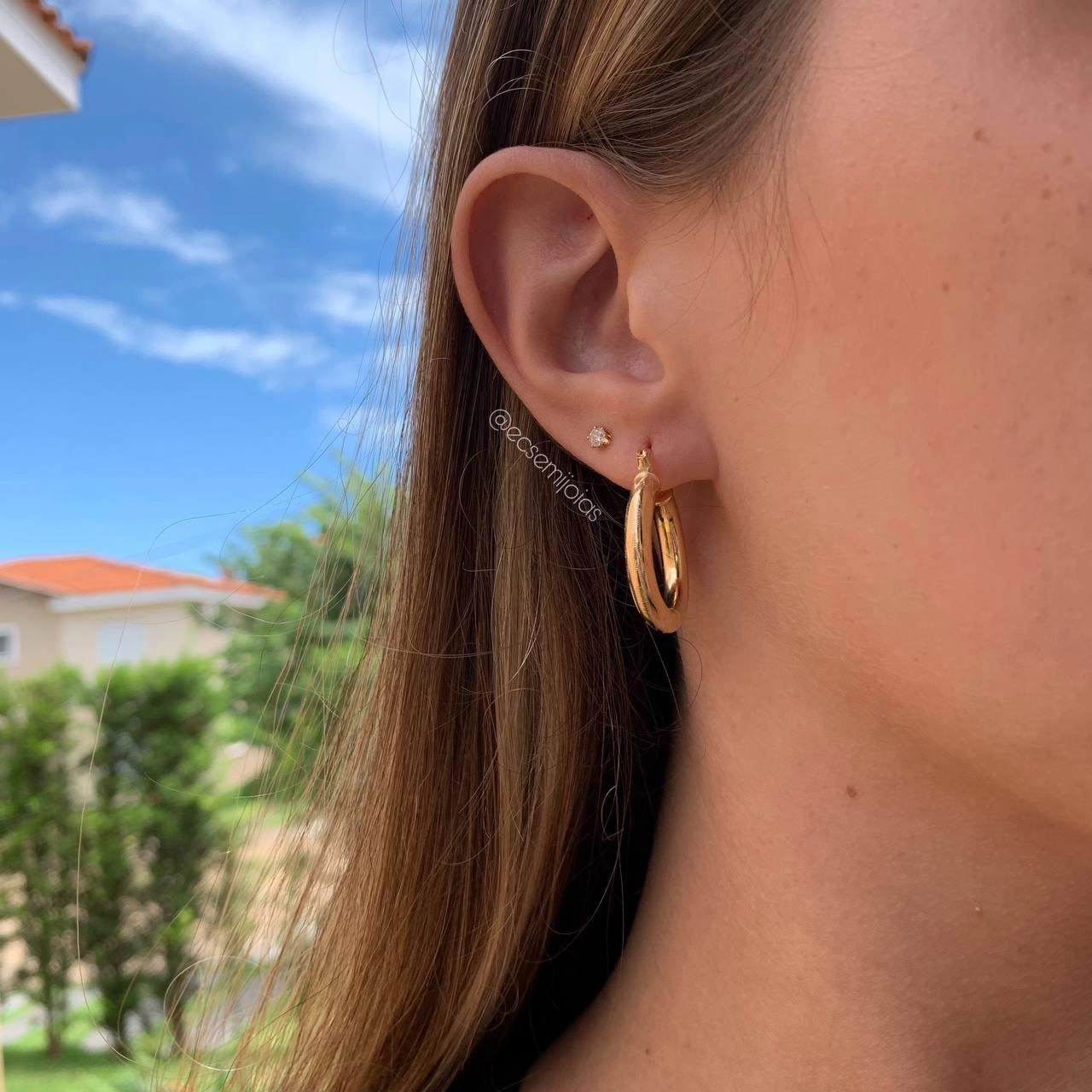 Argola tubular trabalhada diamantado flecha - banhado a ouro 18k