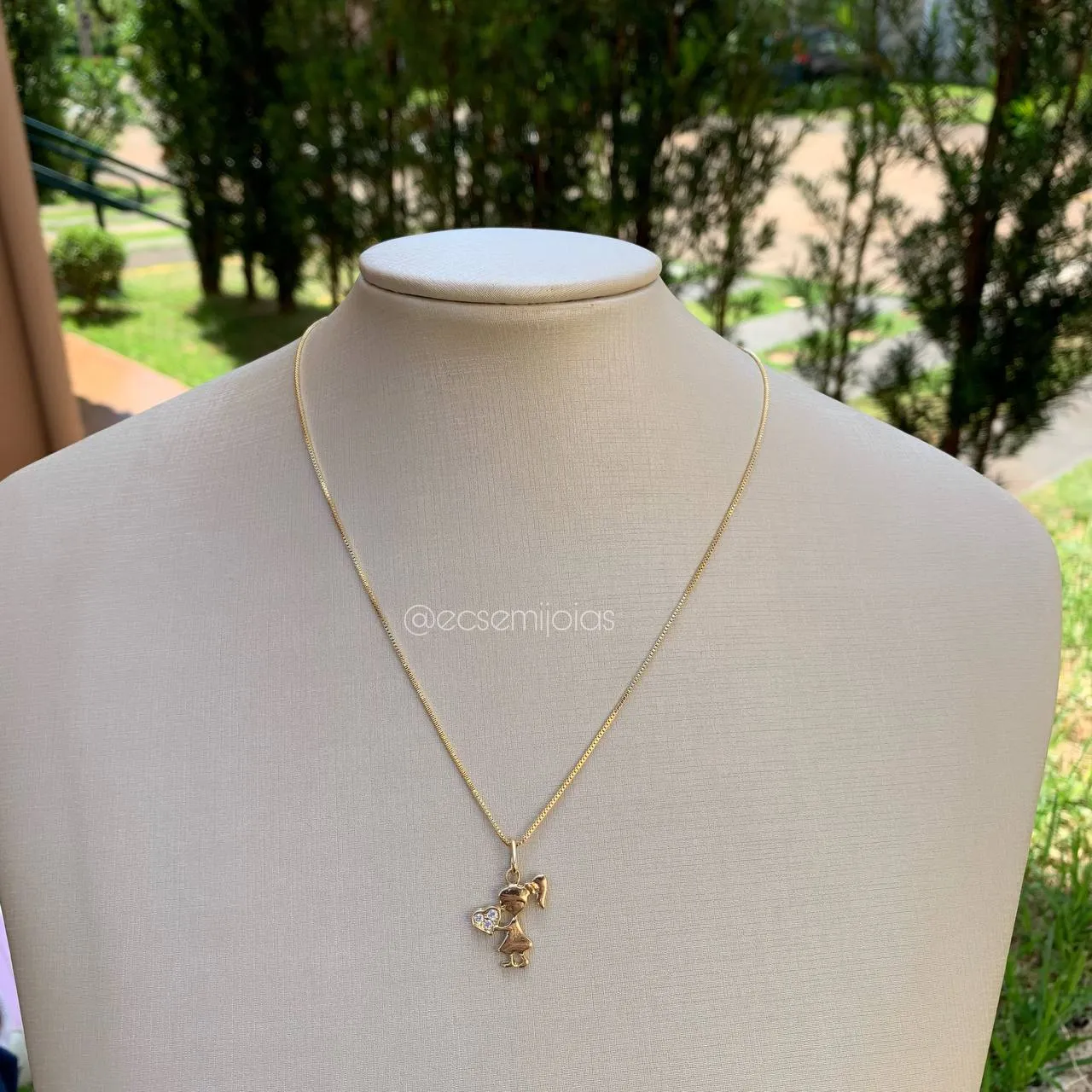 Colar menina segurando coração cravejado - banhado a ouro 18k