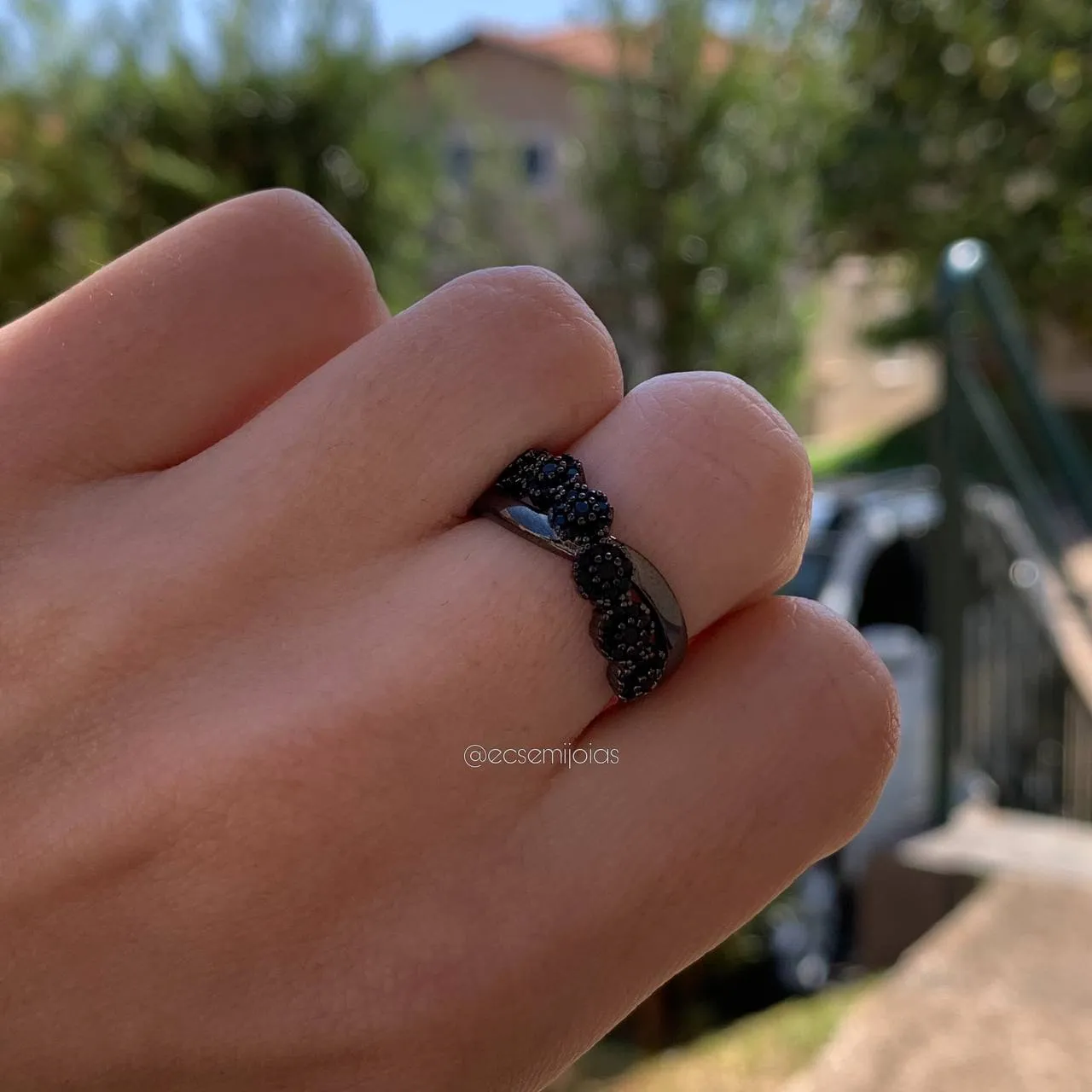 Anel com seis flores cravejadas com pedra e rodium negro aro interlaçado - banhado a ródio negro
