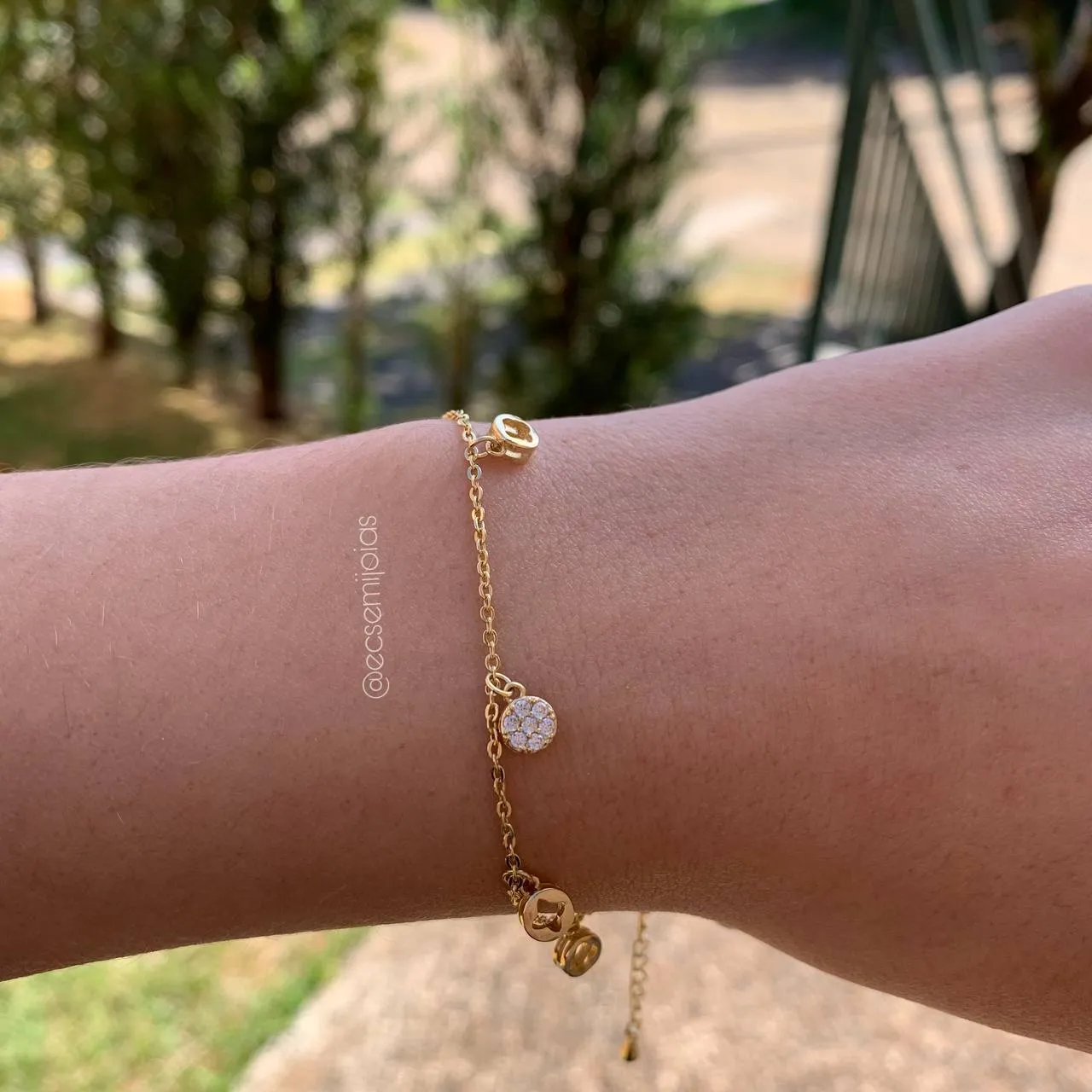 Pulseira fininha com rodinhas penduradas com x vazado e uma cravejada no centro - 20 cm - banhado a ouro 18k
