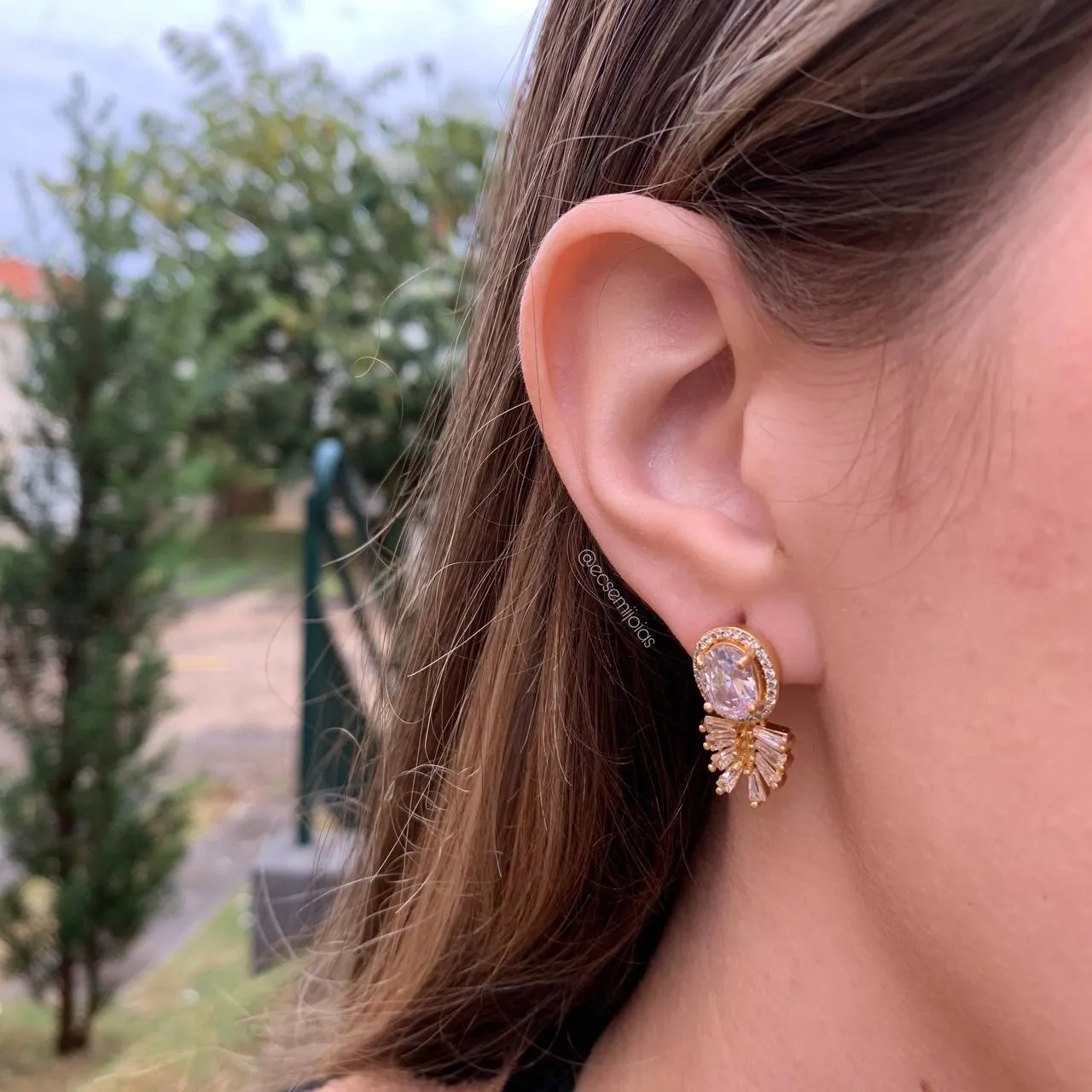 Brinco pedra oval no centro cravejada em volta com folha de baguetes embaixo - banhado a ouro18k