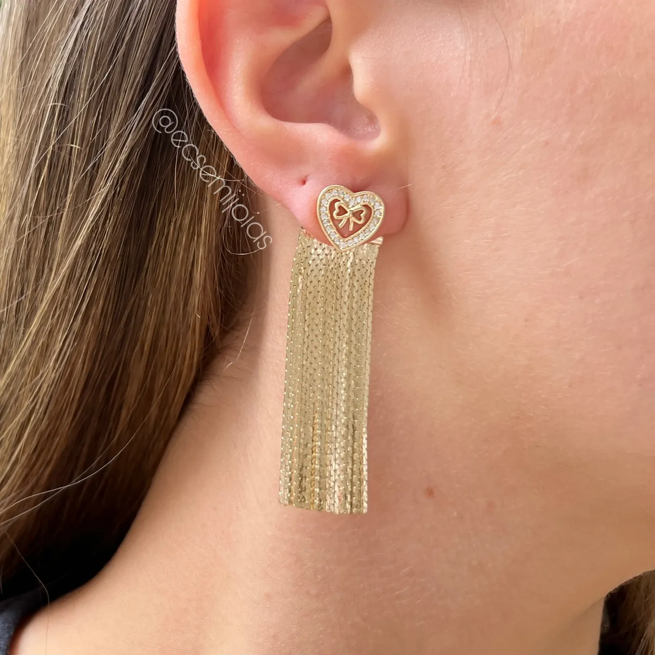 Brinco franja ear jacket com coração cravejado vazado com laço no centro - banhado a ouro 18k