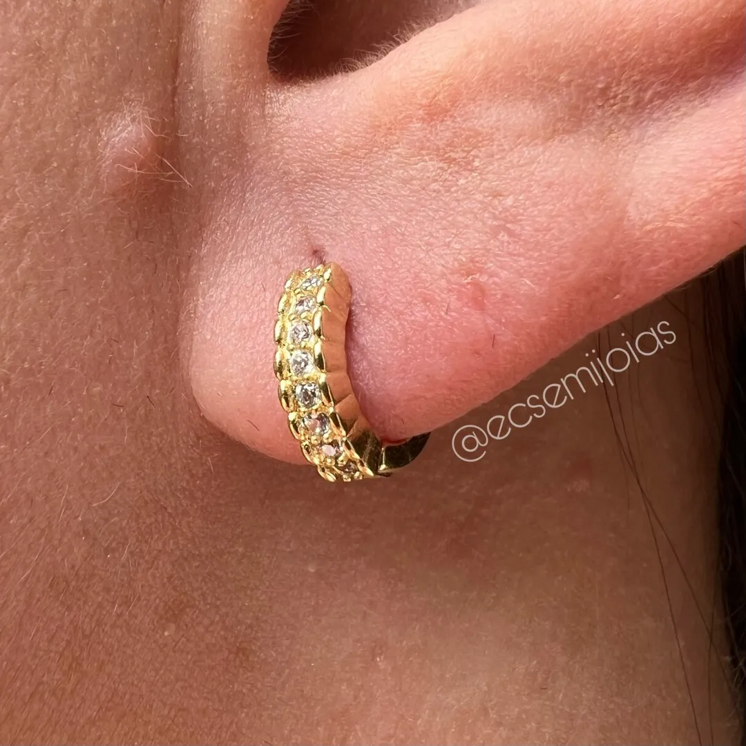 Argola tranqueta com 1 fileira cravejada com bordas e laterais trabalhadas - 12mm - banhado a ouro 18k