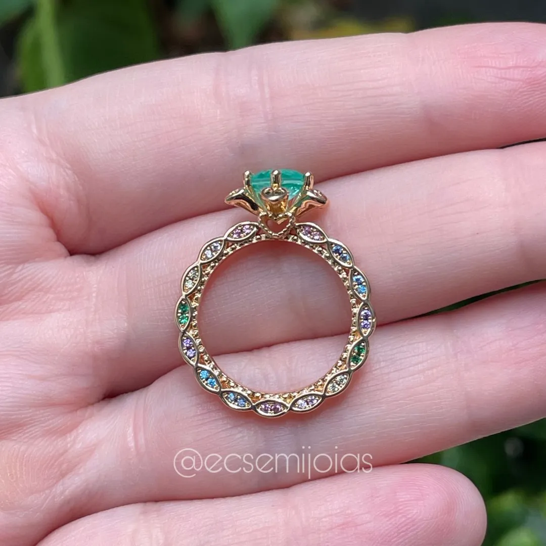 Anel com solitário formato de flor, com pedra redonda, cravejado no aro em cima e laterais - banhado a ouro 18k