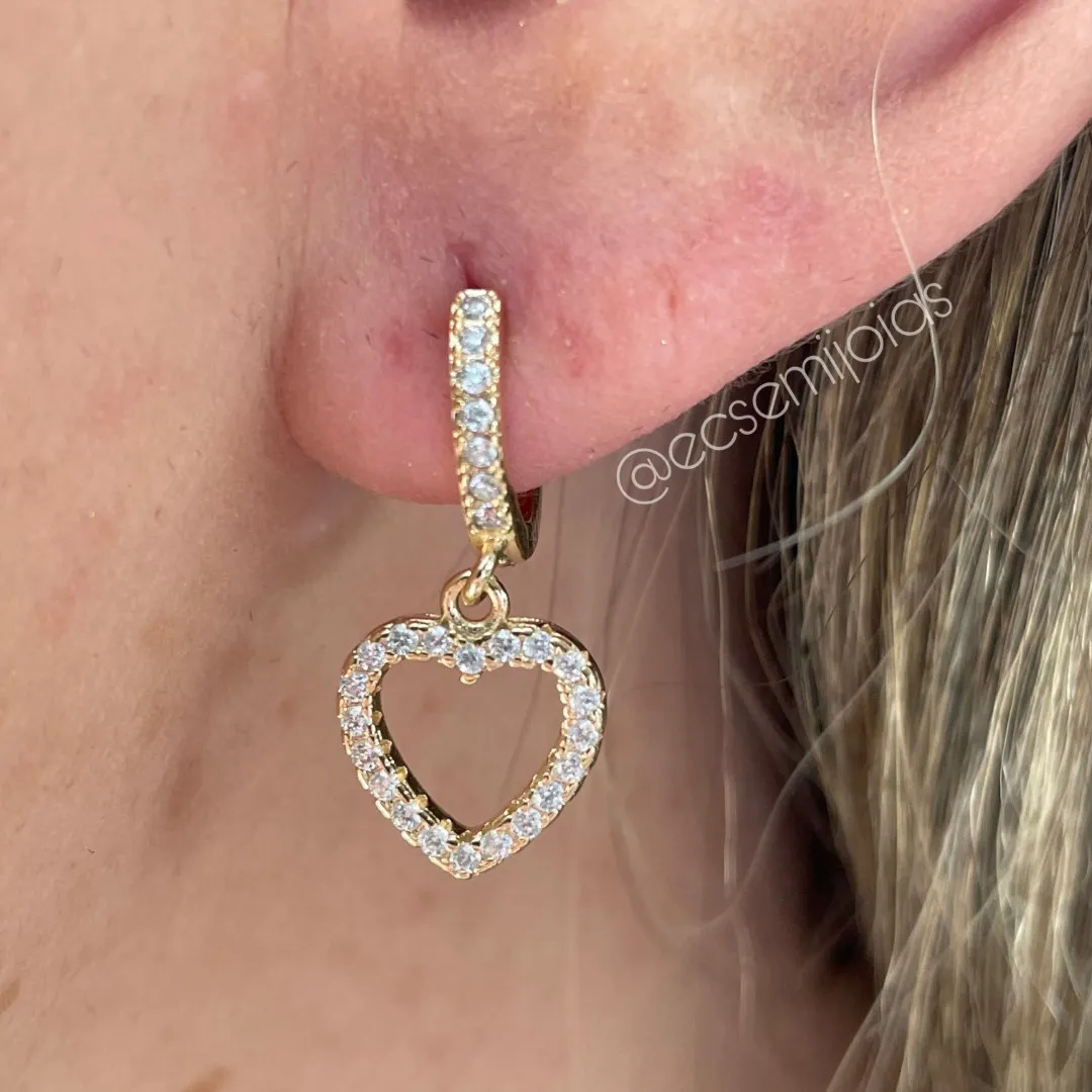 Argola tranqueta com 1 fileira cravejada e pingente de coração vazado cravejado - banhado a ouro 18k