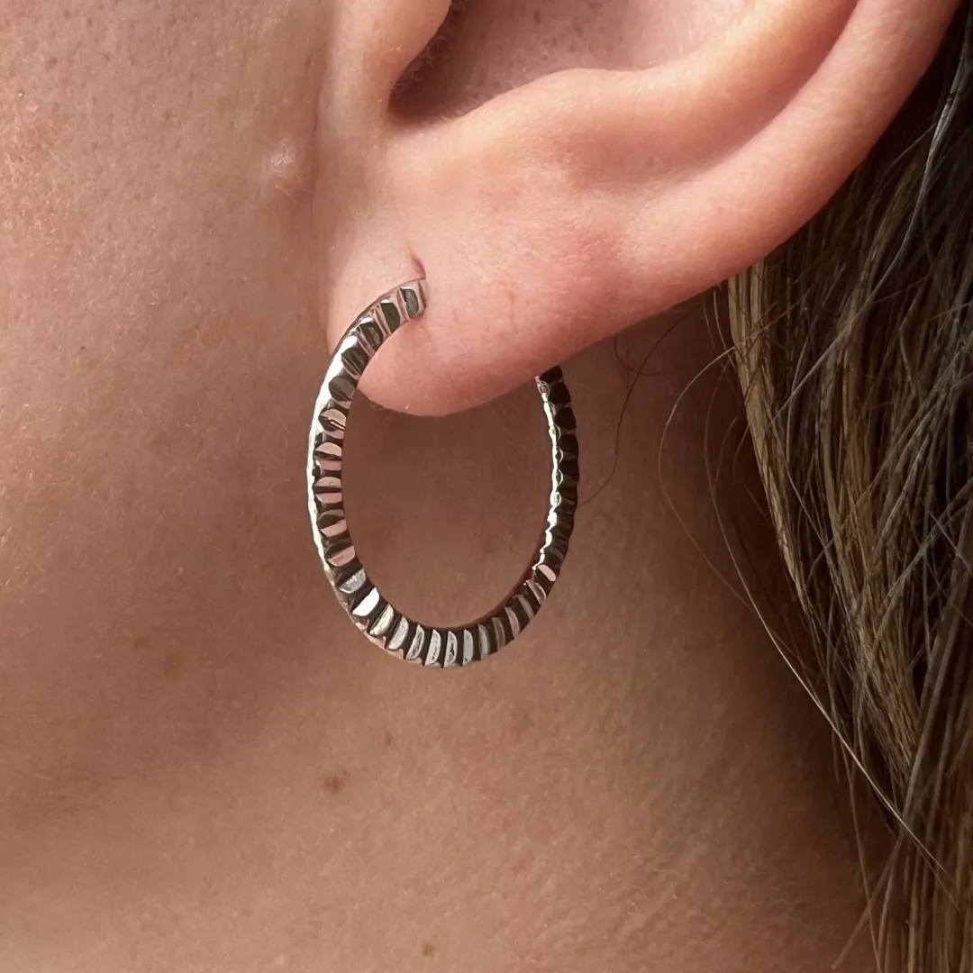 Argola lisa com laterais trabalhadas em relevos - 25mm - banhado a ródio branco