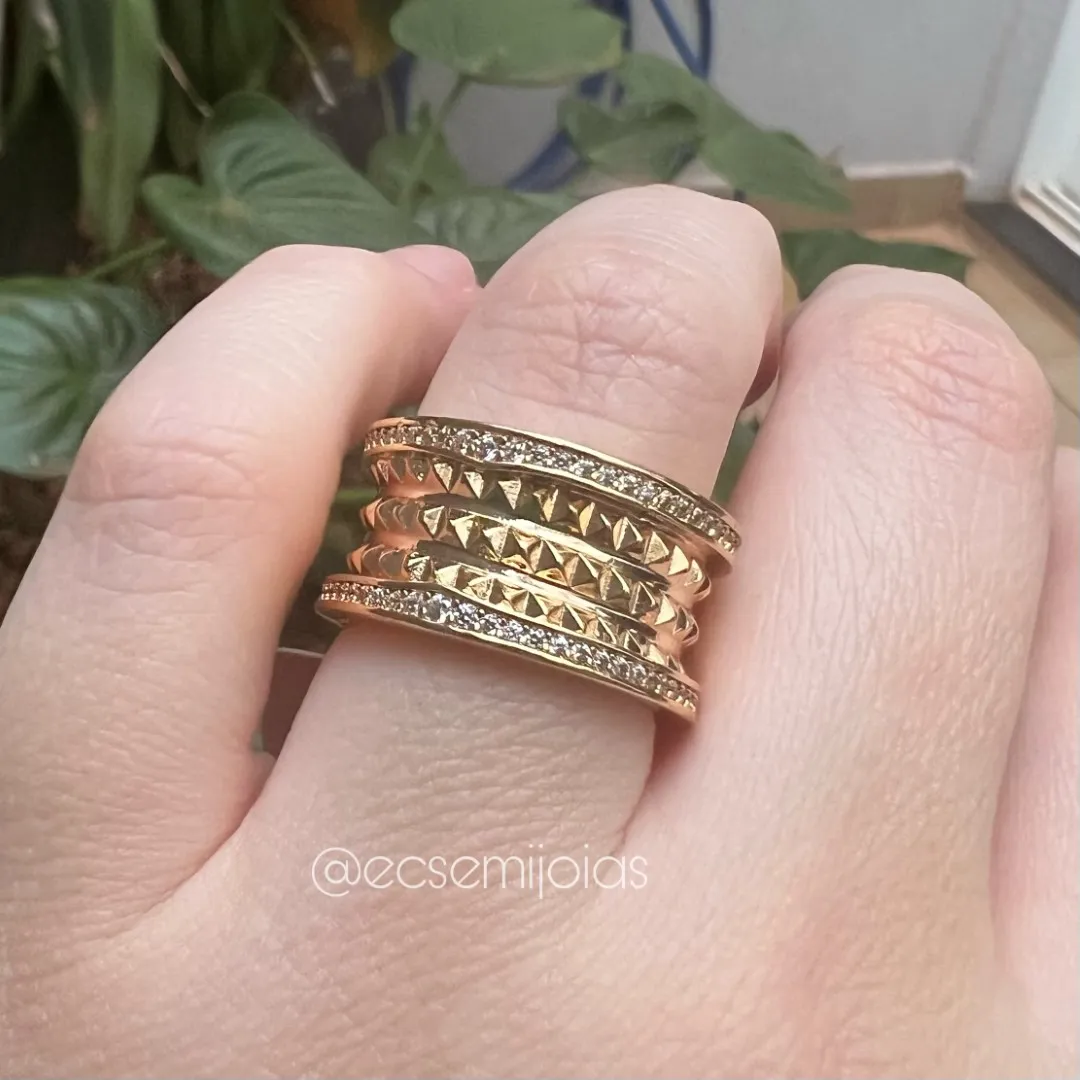 Anel com bordas cravejadas e 3 fileiras com triângulos lisos no centro - banhado a ouro 18k