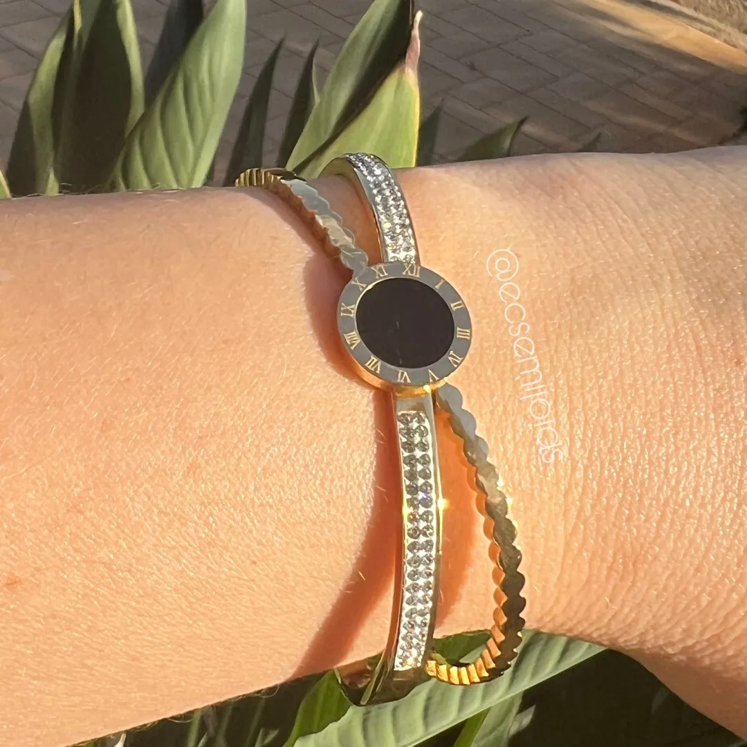 Bracelete com pedra redonda no centro e aro em X cravejado - aço dourado