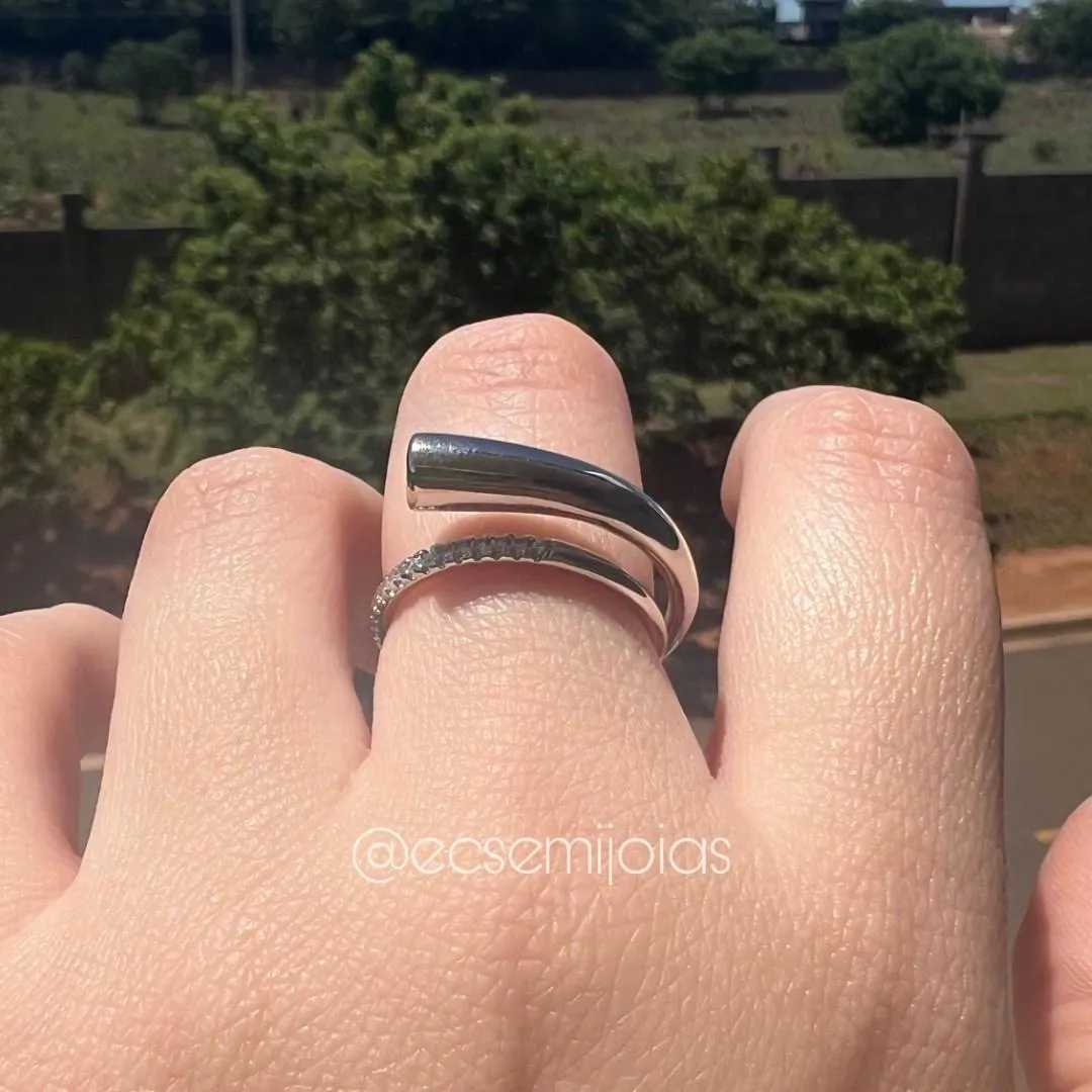 Anel com tubo liso arredondado em cima com 1 zircônia na ponta com aro cravejado - banhado a ródio branco