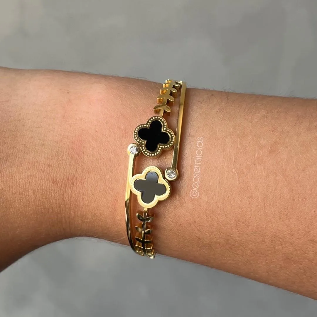 Bracelete com trevo e 1 zircônia de cada lado, aro com folhinhas - aço dourado