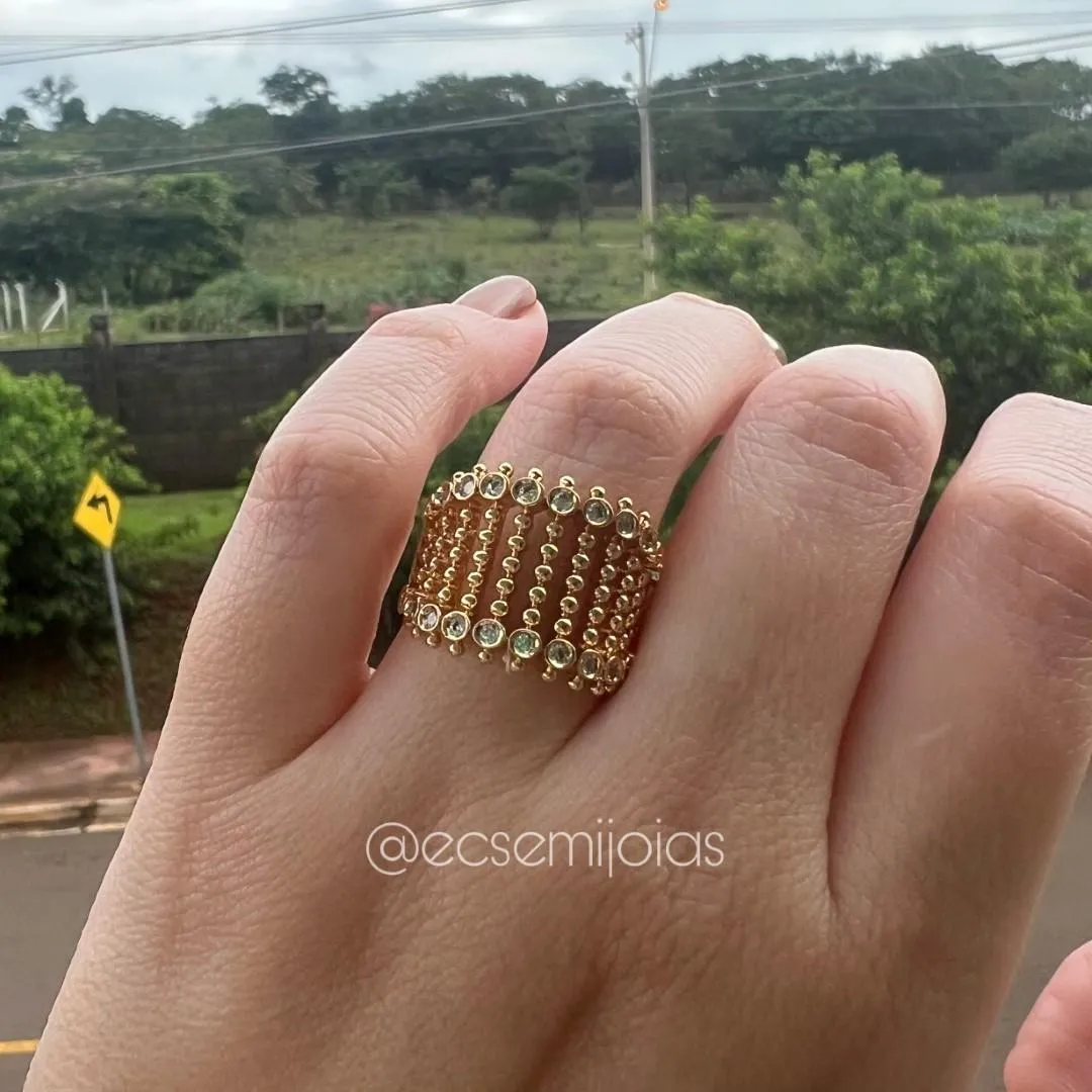 Anel com filetes bombardeados bazados no centro cravejado nas bordas - banhado a ouro 18k