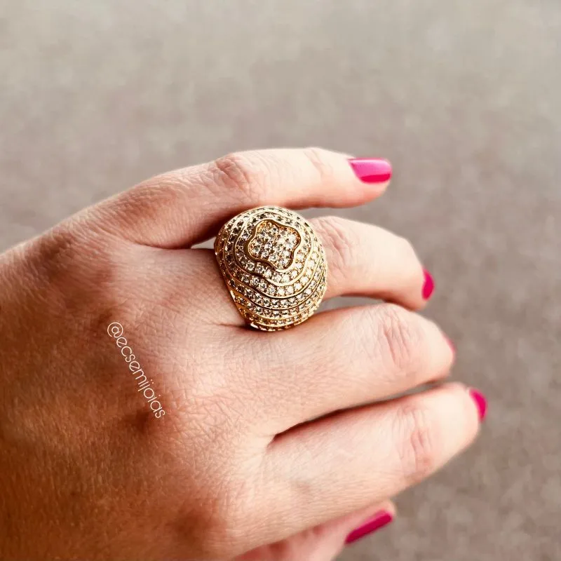 Anel oval grande cravejado com com desenho de trevo no centro e filetes em volta  - banhado a ouro 18k