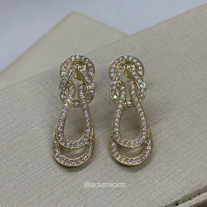 Brinco com aros dando nó cravejado  - banhado a ouro 18k