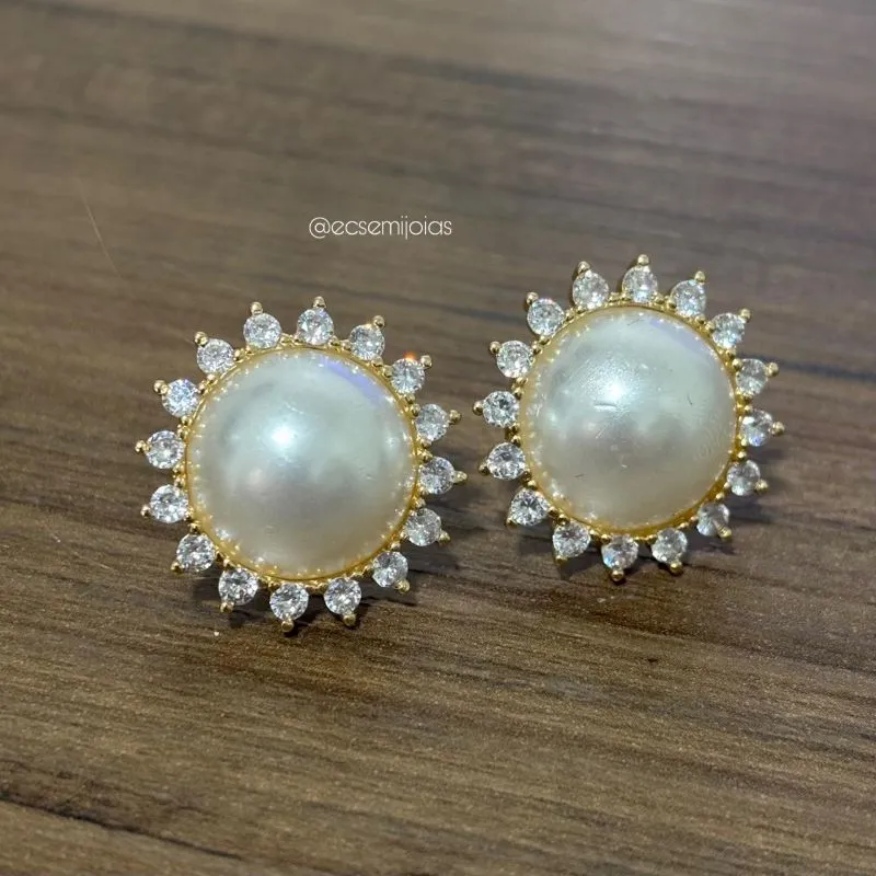 Brinco flor redonda com bordas cravejadas e pérola meia lua no centro - banhado a ouro 18k