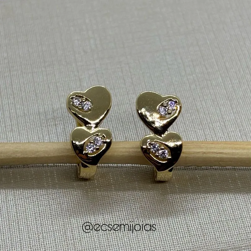 Argola com 2 corações lisos com detalhes cravejados - banhado a ouro 18k